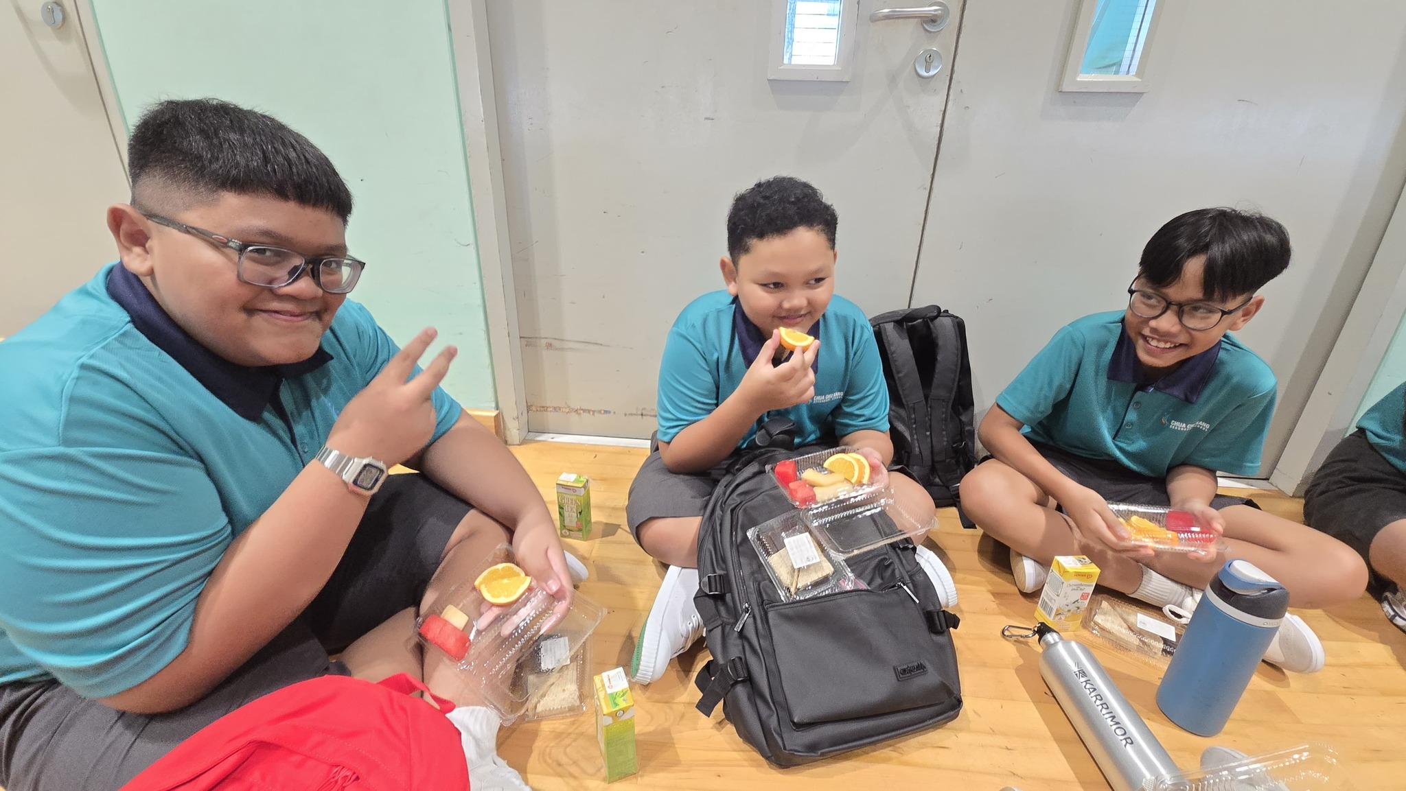 3 students sit down and eat refreshments